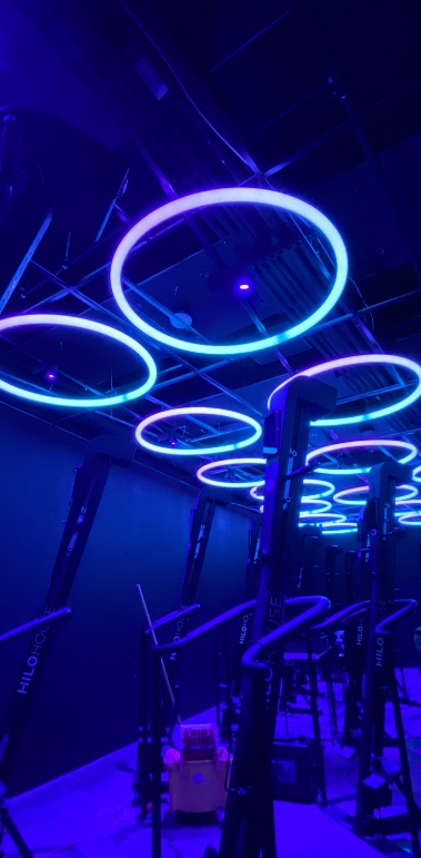 A Room With Neon Blue And Purple Circle Lights On The Ceiling.
