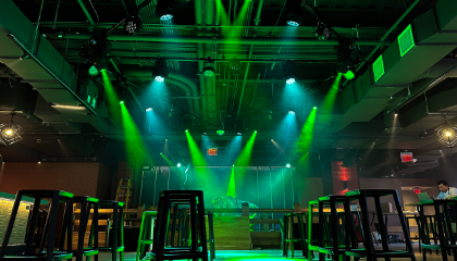 An Empty Bar With A Stage And Green Neon Lights.